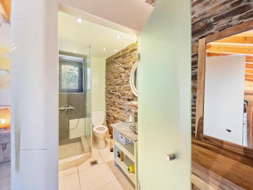 ein Badezimmer mit einer Steinmauer in der Unterkunft Ikaria View Resort and Villa with Pool in Arethousa
