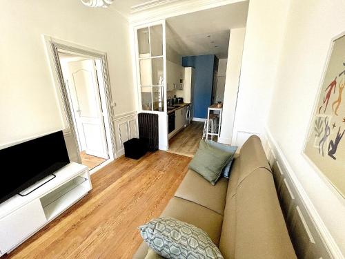 uma sala de estar com um sofá e uma televisão em Confortable 2 pièces au cœur de dreux #2 em Dreux