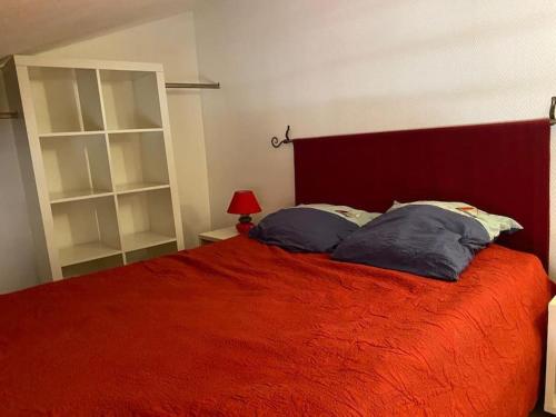 a bedroom with a red bed with a red blanket at Petite maison quartier hist in Collioure