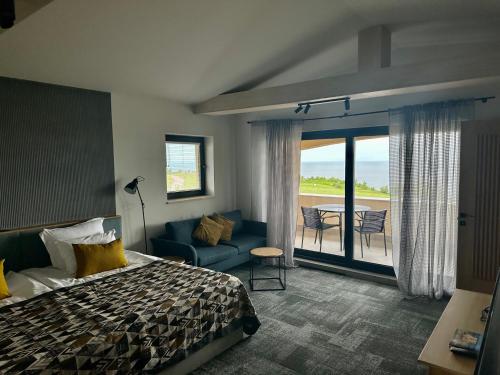a bedroom with a bed and a couch and a patio at BlackSeaRama Golf & Villas in Balchik