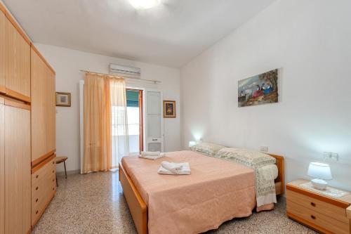 una camera con letto, cassettiera e finestra di Casa di Emanuela a San Foca