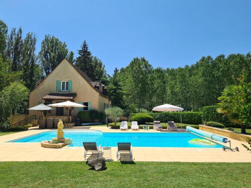 ein Swimmingpool mit zwei Katzen, die im Gras sitzen in der Unterkunft Le Malpas Kingfisher in Belvès