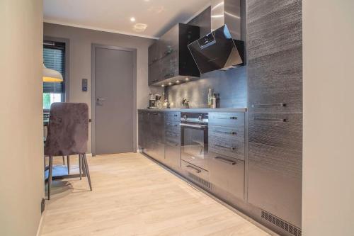 a kitchen with stainless steel appliances and a wooden floor at Near Brosundet, Newly Refurnished, Free Street Parking in Ålesund