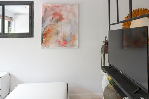 a living room with a couch and a painting on the wall at Cozy Apartment - Old City ChiangMai PRIME Location in Chiang Mai
