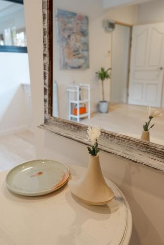a vase sitting on a counter in front of a mirror at Cozy Apartment - Old City ChiangMai PRIME Location in Chiang Mai