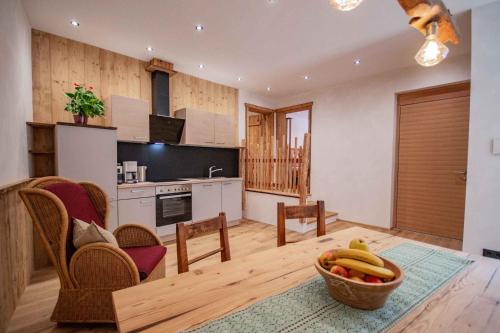a living room with a kitchen and a bowl of fruit at Peerfect Ferienwohnungen in Navis