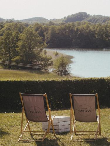 two chairs sitting in front of a body of water at Willa MM Kaszuby in Łapalice