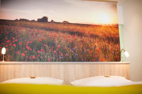 a painting of a poppy field with two beds at Café & Wein Gästehaus Kurz in Heilbronn