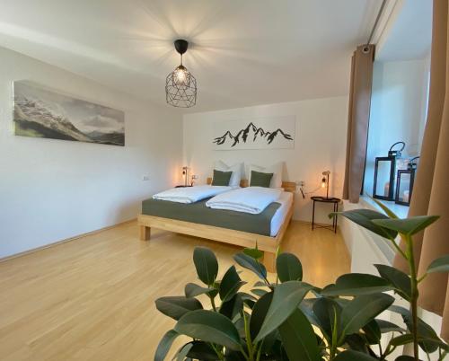 a bedroom with a bed and a potted plant at Moderne Ferienwohnung im Allgäu in Erkheim