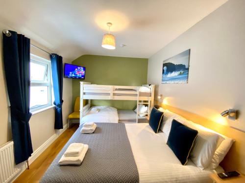 a bedroom with a bed and a bunk bed at Beulah Guest House in Portrush