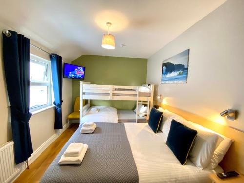 1 dormitorio con 1 cama y 1 litera en Beulah Guest House, en Portrush