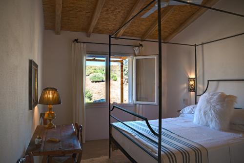 een slaapkamer met een hemelbed en een raam bij Auberge Santu Martine Cottage with Pool (Ollastru) in Galtellì