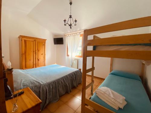 1 dormitorio con 1 cama y 1 litera en Locanda Del Boscaiolo, en Monasterolo del Castello