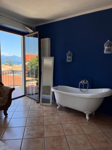 ein Badezimmer mit einer Badewanne und einer blauen Wand in der Unterkunft The Tower Of The Old King in Desenzano del Garda