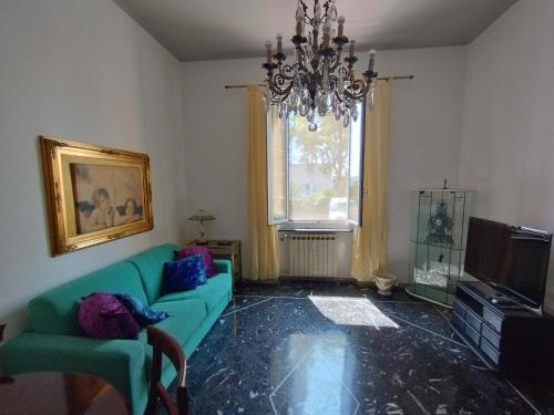 sala de estar con sofá verde y lámpara de araña en Casa Nonna Anna, en Génova