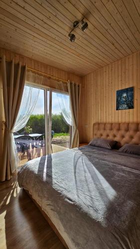um quarto com uma cama grande e uma janela grande em R&J Venslaviskiai 