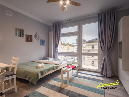 - une chambre avec un lit et une grande fenêtre dans l'établissement Lemonade Nowogrodzka, à Varsovie
