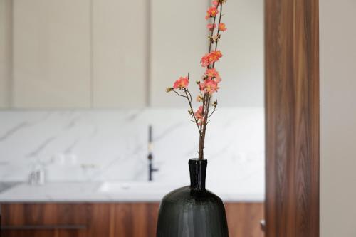 a black vase with flowers in it in a kitchen at Vanda's Maison in Corfu Town