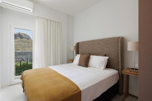 a bedroom with a large bed and a window at Vanda's Maison in Corfu Town