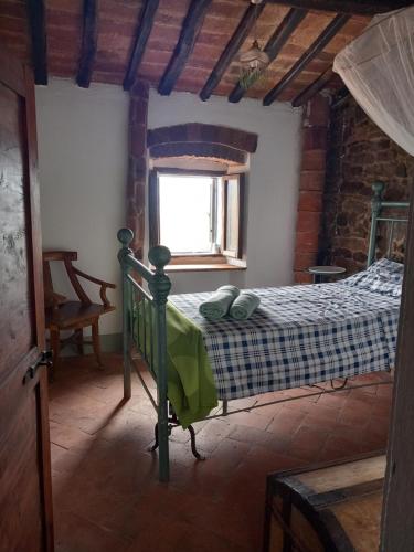 a bedroom with a bed in a room with a window at La Cannicciaia in Montale