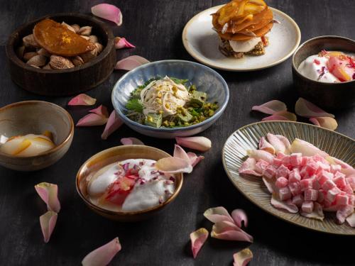 a table topped with plates of food and flowers at Hotel Le K2 Altitude in Courchevel