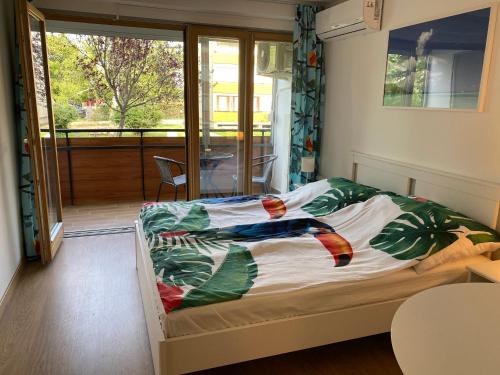 a bedroom with a bed with a view of a balcony at Aranyhíd B-1 apartman in Balatonfüred