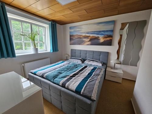 a bedroom with a bed with a painting on the wall at FEWO Weissenhäuser Strand in Wasbuck