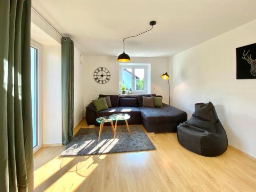 a living room with a bed and a couch at Moderne OG-Wohnung im Allgäu in Erkheim
