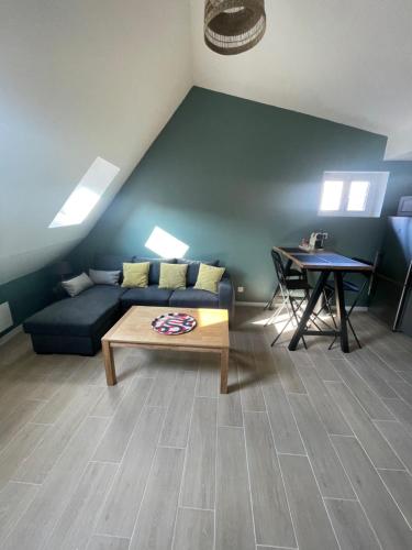 un salon avec un canapé bleu et une table dans l'établissement Résidence la Chevalerie, à Bayeux