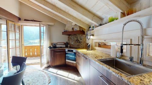 a kitchen with a sink and a large window at Chalet Zeppelin in Chateau-d'Oex