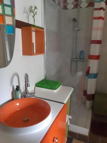 La salle de bains est pourvue d'un lavabo rouge et d'une douche. dans l'établissement HAUT DE VILLA au MONT ST CLAIR VUE EXCEPTIONNELLE MER et FORÊT terrasses, piscine, pétanque, solarium privés, à Sète