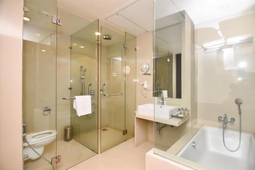 a bathroom with a shower and a toilet and a sink at Regenta Central Grand Exotica in Pune