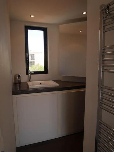 une salle de bain avec un lavabo et une fenêtre dans l'établissement UNIQUE! APPART TOIT TERRASSE - 100m MER, à Marseille