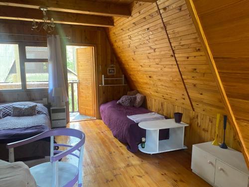Zimmer im Dachgeschoss mit einem Bett und einem Tisch in der Unterkunft „Lawendowy Domek” nad jeziorem Gim in Teerau