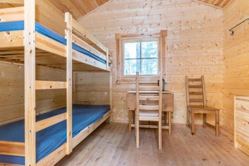 a cabin with two bunk beds and a desk at Karhunkierros Cabins & Huts in Salla