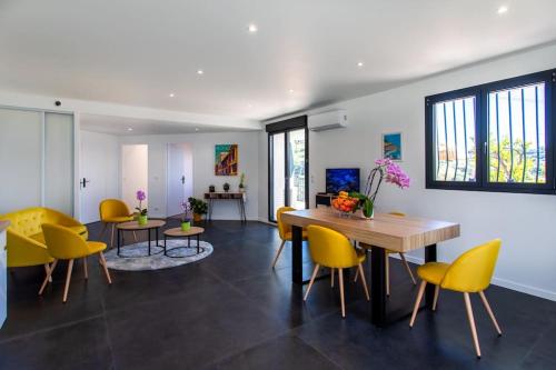 une salle à manger avec des chaises jaunes et une table dans l'établissement Echapée Belle - Vinayard view - Jacuzzi BBQ - parking, à Nice