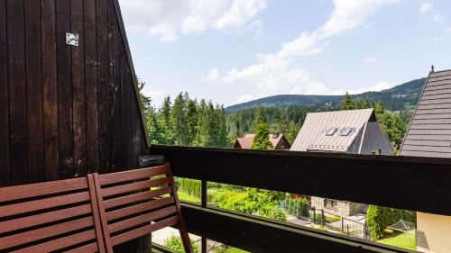 a wooden bench sitting on a balcony with a view at Apartament Krzeptowskiego 33 in Zakopane