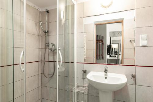 a bathroom with a sink and a glass shower at Apartament Krzeptowskiego 33 in Zakopane