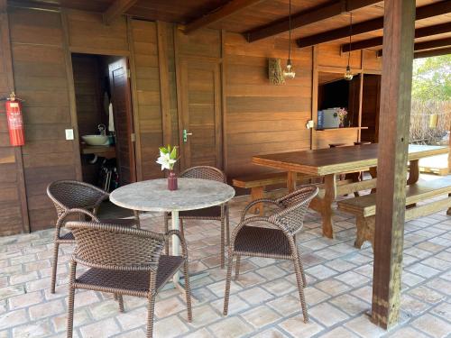 a patio with a table and chairs and a dining room at Atins Bangalôs in Atins