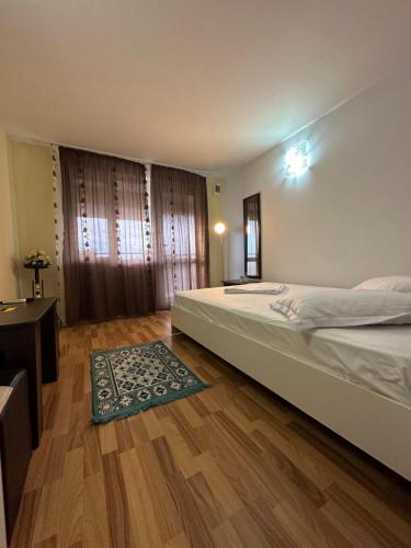 a bedroom with a large bed and a wooden floor at Casa Cu Flori Corbu in Corbu