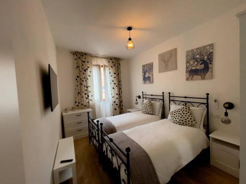 a bedroom with two beds and a television in it at acasasiena in Siena