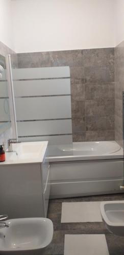 uma casa de banho com uma banheira, um lavatório e um WC. em Apartament lux em Roman