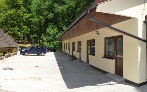 a building with a car parked next to a street at Penzion a Restaurace Pintovka in Tábor