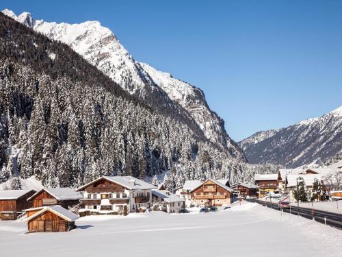 a village covered in snow in front of a mountain at Apartment in Pitztal near Ski Glacier in Oberlehn