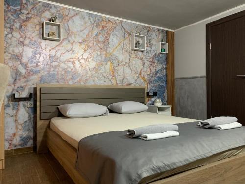 a bedroom with a bed with two towels on it at Apartman Daca in Podgorica