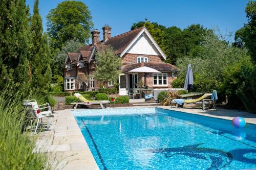 una casa con piscina frente a una casa en The Lodge en New Milton