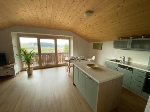 eine große Küche mit einem Tisch und einem großen Fenster in der Unterkunft Ferienhaus am Wald in Friesenried