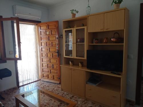 una sala de estar con un gran centro de entretenimiento con TV en Casa Azul, en Los Alcázares
