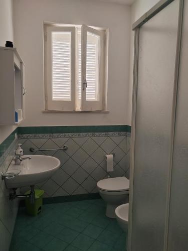 a bathroom with a sink and a toilet and a window at Villaglauca in Maratea