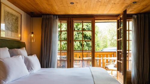 a bedroom with a bed and a balcony at Chalets de l'Alpaga in Megève